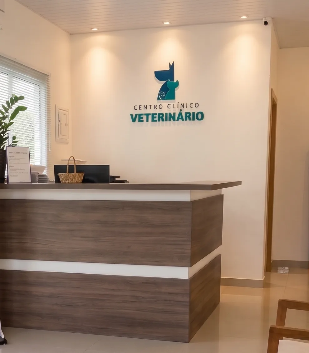 Recepção da clínica, com balcão de madeira e o logo do Centro Clínico Veterinário na parede